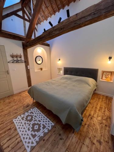 a bedroom with a large bed and a wooden floor at appartement chaleureux in Honfleur