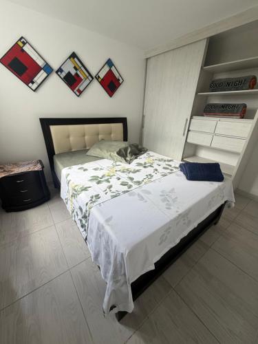 a bedroom with a large bed and a shelf at Descanso Ideal in Manizales