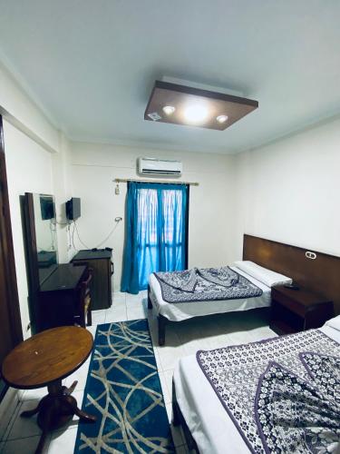 a room with two beds and a table and a desk at فندق الليدو in Marsa Matruh