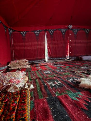 a room with red walls and a bed and carpet at Waatad in Irbid