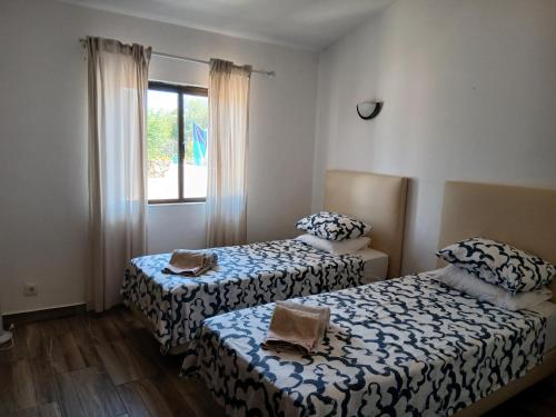 a room with two beds and a window at Casa no Campo in Algoz