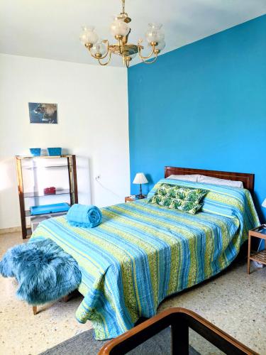 a bedroom with a bed with a blue wall at Casa Ti Mielga in Ayoó de Vidriales