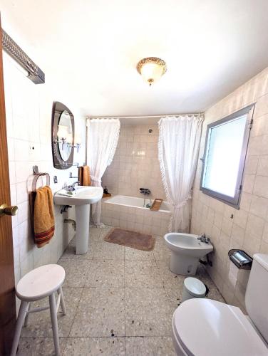 a bathroom with a tub and a sink and a toilet at Casa Ti Mielga in Ayoó de Vidriales