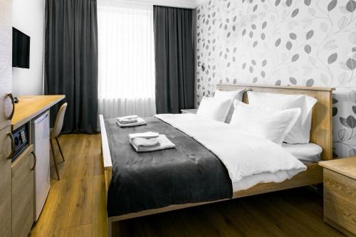 a bedroom with a large bed with white pillows at Hotel Caucasus Borjomi in Borjomi