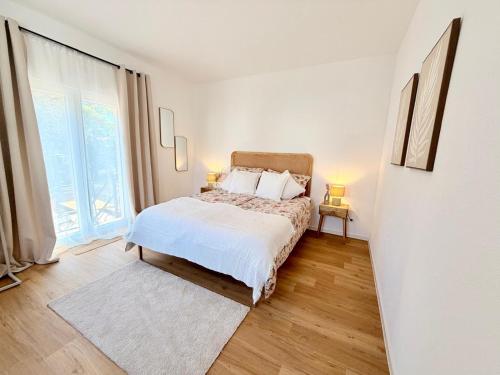 a white bedroom with a bed and a large window at Markt-Quartier in Nierstein