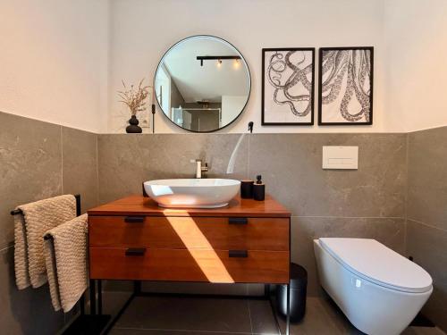 a bathroom with a sink and a toilet and a mirror at Markt-Quartier in Nierstein
