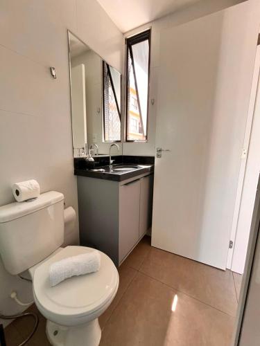 a bathroom with a white toilet and a sink at Solon Flat Manaira in João Pessoa