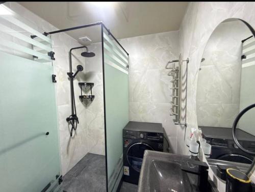a bathroom with a sink and a washing machine at Bekh House SAM in Samarkand