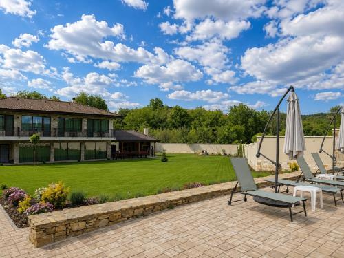 a patio with two lounge chairs and an umbrella at Gracia House in Mogilovo