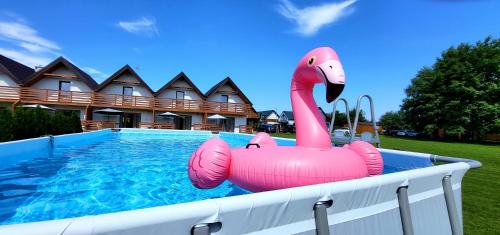 a pink inflatable flamingo in a swimming pool at Domki Lilia Sarbinowo in Sarbinowo