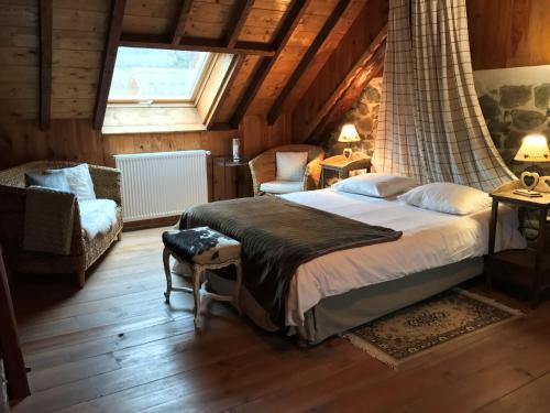 a bedroom with a large bed and a window at La Clé des Bois in Le Bourg-dʼOisans