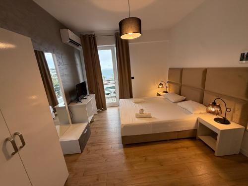 a bedroom with a white bed and a window at Diamond Prestige Hotel in Sarandë