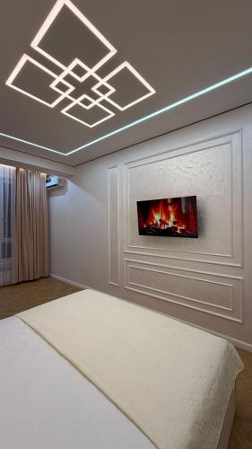 a living room with a fireplace and a tv on the wall at Capital city in Shymkent