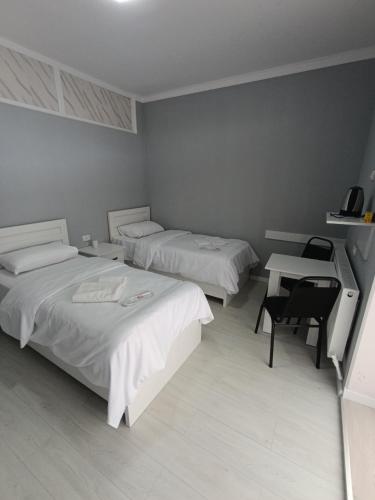 a room with two beds and a desk and a table at VSt GRAND HOTEL in Ninotsminda