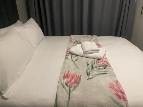 a bed with a blanket with a hat on it at Leeba Apartments in Maseru