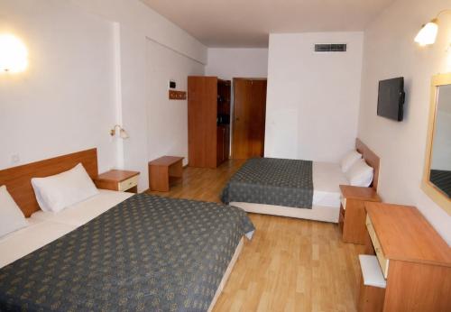 a hotel room with two beds and a television at Hotel Filoxenia Beach in Leptokarya