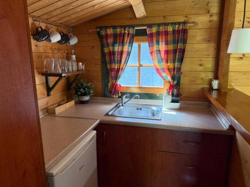 a kitchen with a sink and a window at Wild Life Chalets in Rafína