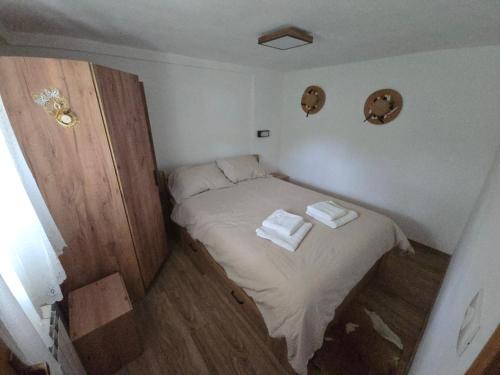 a small bed in a small room with two towels at Apartma Dajana in Lokve