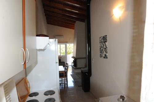 カラモスにあるRossa 18の白い壁と木製の天井のキッチン