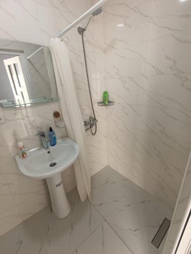 a white bathroom with a sink and a shower at VSt GRAND HOTEL in Ninotsminda