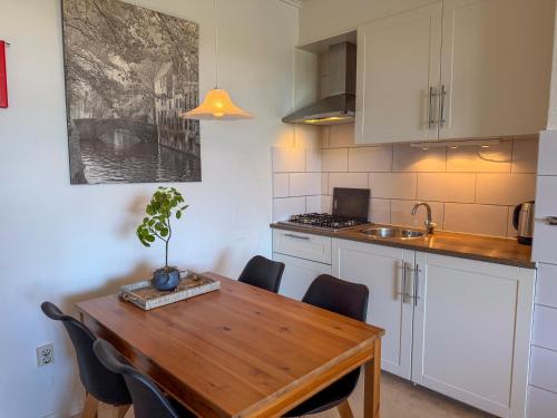 a kitchen with a wooden table with chairs and a sink at Texel-De Koog 116 in De Koog