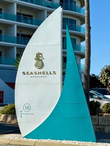 a surfboard sign in front of a building at HAVEN by the Sea in Mandurah
