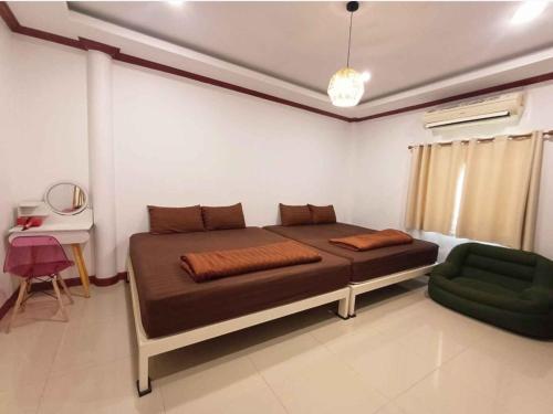 a bedroom with a large bed and a green chair at Gn story love บ้านเกาะล้าน 小珊瑚岛班泳池别墅 in Ko Larn