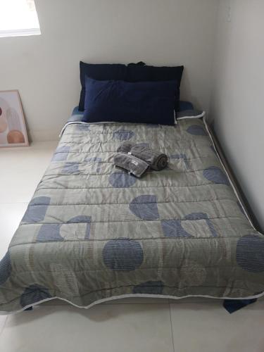 a bed with a blanket with a shoe on it at COLOFT - Quarto 4 Hospedagem rápida ou Sala de reunião in Anápolis