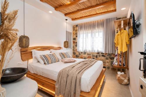 a bedroom with a bed with a wooden headboard at Boriadon Rustic Countryside Homes in Naxos Chora