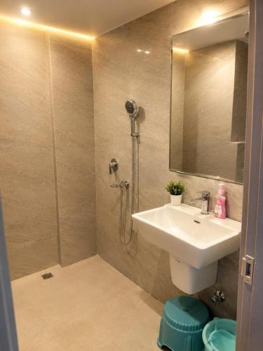 a bathroom with a sink and a shower with a mirror at Velvet Nook in Greater Noida