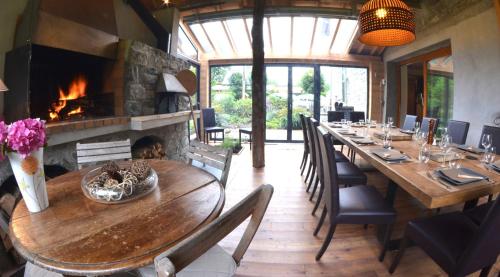 une salle à manger avec une grande table et une cheminée dans l'établissement La Clé des Bois, au Bourg-dʼOisans