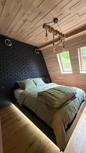 a bed in a room with a wooden ceiling at Mia A-Frame Chalet Cheia in Cheia
