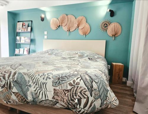 a bedroom with a bed and a blue wall at Le Chalet de Pyrène et Hercule in Arignac