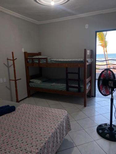 a bedroom with two bunk beds and a view of the ocean at Hotel Panorama do Mar - Praia do Futuro in Fortaleza