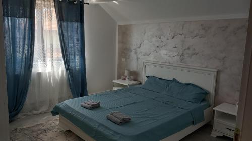 a bedroom with a bed with two towels on it at Casa A&A Stefan Livada in Livada