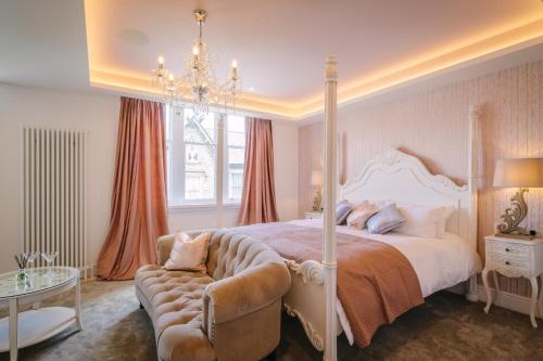 a bedroom with a large bed and a chandelier at Absoluxe Suites in Kirkby Lonsdale