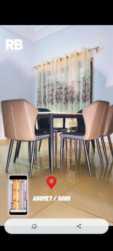 a dining room with a table and two chairs at RÉSIDENCES Bhelmar in Abomey
