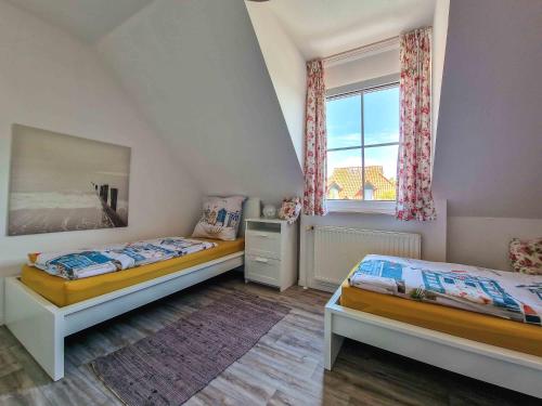 a bedroom with two beds and a window at Liekedeeler in Greetsiel