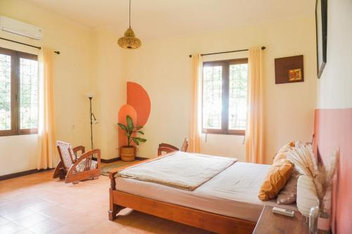 a bedroom with a bed and two windows at Roemah Nelayan in Montongbuwoh