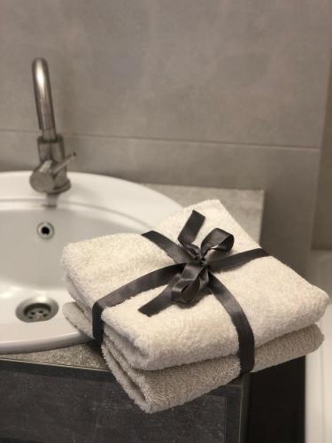 a white towel with a black ribbon sitting on a sink at New Marine Apartment in Yuzhne