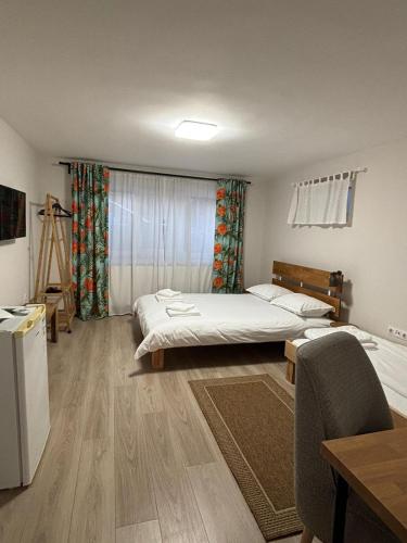 a room with two beds and a chair and a table at TamTam Urban in Cluj-Napoca