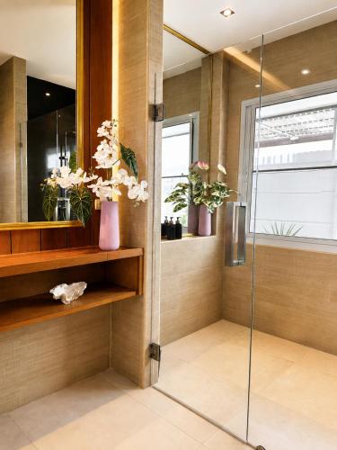 a bathroom with a shower with vases of flowers at Aufwachen im Paradies Private Poolvilla 50 m vom Strand in Nathon Bay