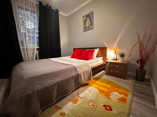 a bedroom with a bed with a red pillow and a window at InCentrum Pańska 3 in Warsaw