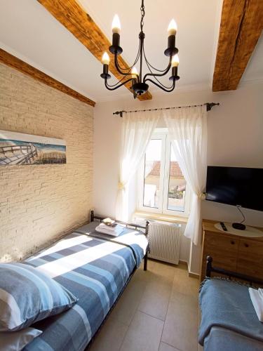 a bedroom with a large bed and a tv at Holiday House - OLD QUEEN in Šmrika