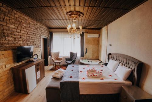 a bedroom with a large bed and a living room at Konak Stone House in Ürgüp