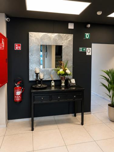 a dressing table with a mirror on a wall at Hotel Taormina Brussels Airport in Zaventem