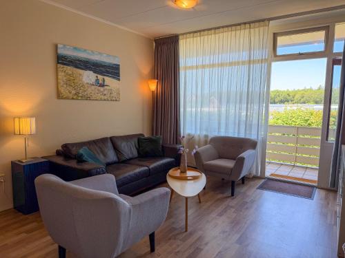 a living room with a couch and chairs and a window at Texel-De Koog 116 in De Koog