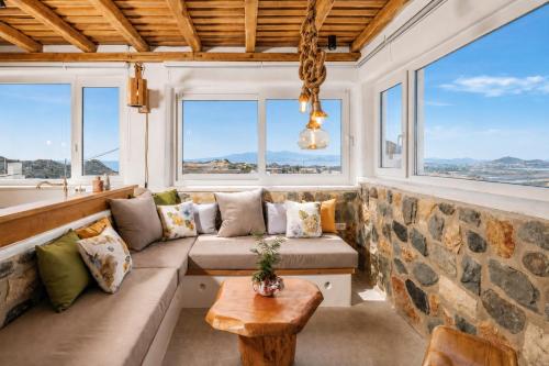 a living room with a couch and windows at Boriadon Rustic Countryside Homes in Naxos Chora
