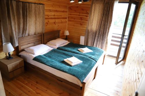 a bedroom with a bed with two towels on it at Cottage Mildiani in Mestia