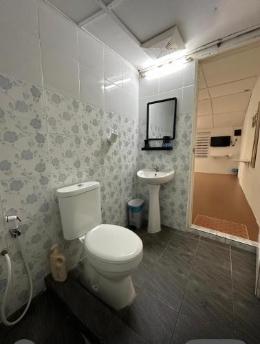 a bathroom with a toilet and a sink at Ruma in Cherating